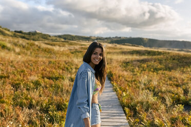 Spanien, Asturien, schöne junge Frau an der Strandpromenade am Abend - MGOF002219