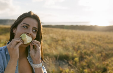 Spanien, Asturien, schöne junge Frau isst einen Apfel - MGOF002221