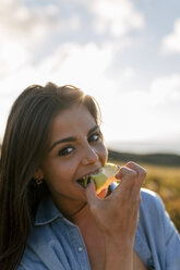 Spanien, Asturien, schöne junge Frau isst einen Apfel - MGOF002222