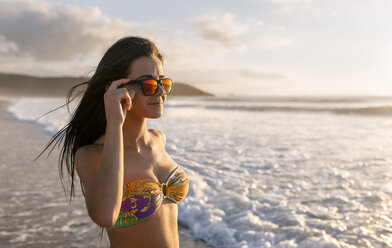 Spanien, Asturien, schöne junge Frau am Strand bei Sonnenuntergang - MGOF002226