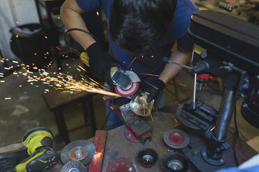 Schmied schleift Metall in der Werkstatt - FMOF000107