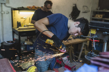 Schmied schleift Metall in der Werkstatt - FMOF000108