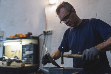 Schmied beim Hämmern von Metall in der Werkstatt - FMOF000113