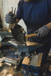 Schmied beim Hämmern von Metall in der Werkstatt - FMOF000115