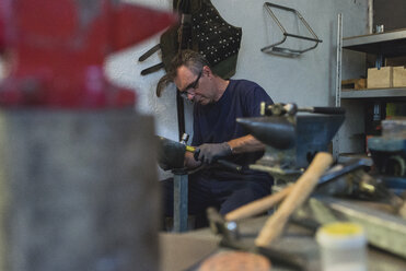 Forger hammering metal in workshop - FMOF000117