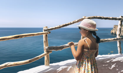 Kleines Mädchen steht auf dem Balkon und schaut auf das Meer - MGOF002246