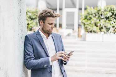 Geschäftsmann schaut auf sein Handy - KNSF000407