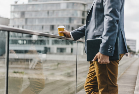 Geschäftsmann stehend auf Brücke mit Kaffee und Tablet, lizenzfreies Stockfoto