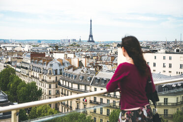 Frankreich, Paris, Frau genießt die Aussicht auf Paris mit dem Eiffelturm im Hintergrund - GEMF000970