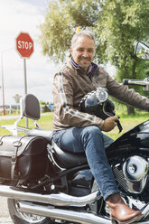 Portrait of man sitting on his motorbike - JUNF000579