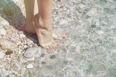 Füße einer jungen Frau am Wasser - JUNF000608