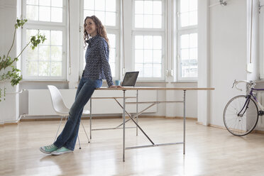 Smiling woman in sparse office - RBF004981