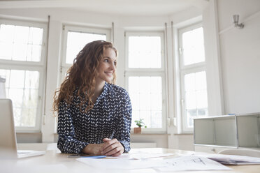 Lächelnde Frau am Schreibtisch im Büro - RBF005001