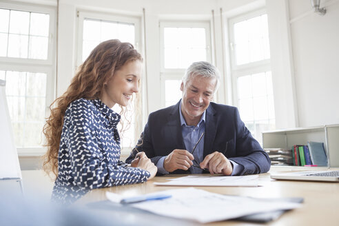 Businessman and woman at desk discussing plans - RBF005008