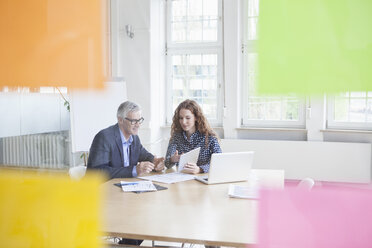 Businessman and woman at desk with tablet - RBF005013