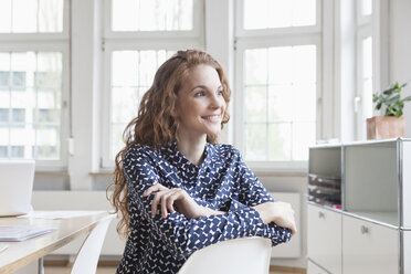 Smiling woman at desk in office - RBF005020