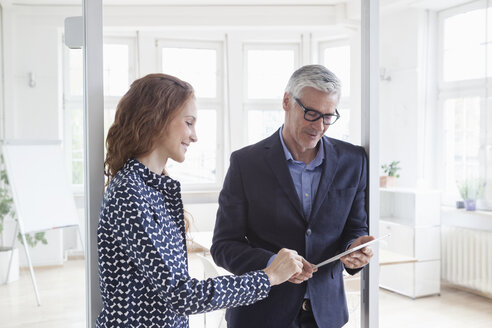 Businessman and woman in office with tablet - RBF005028