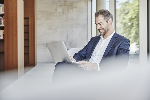 Smiling businesssman using laptop stock photo