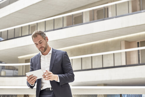 Geschäftsmann mit Tablet im Bürogebäude - FMKF002919