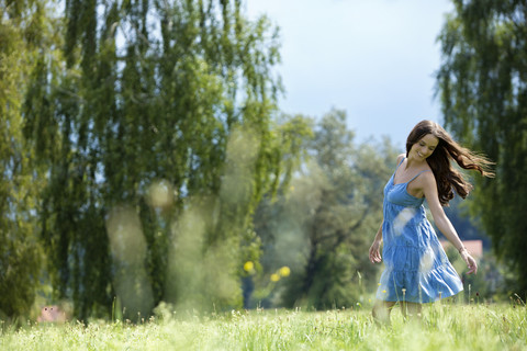 Young woman, blue dress, on meadow stock photo