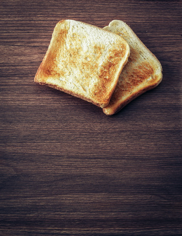 Toast auf dunklem Holz, lizenzfreies Stockfoto