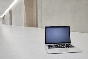 Laptop auf dem Boden eines Bürogebäudes - FMKF002972