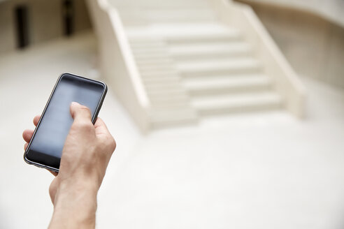 Close-up of man holding smartphone - FMKF002980