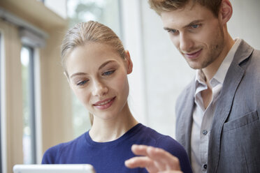 Young man and woman sharing tablet - FMKF003025