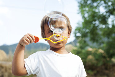 Little boy blowing soap bubbles - VABF000753