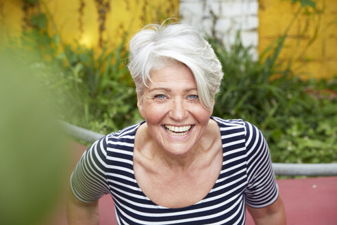 Porträt einer glücklichen Frau im Garten - FMKF003026