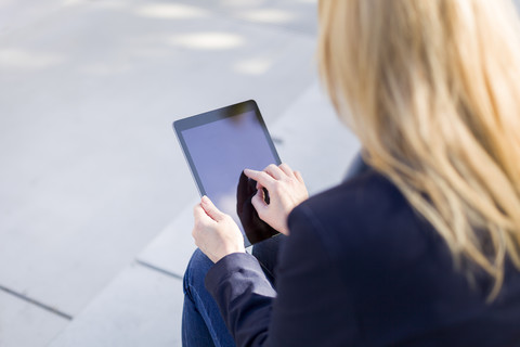 Hand of businesswoman touching display of tablet stock photo