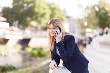 Smiling blond businesswoman on the phone - NAF000031