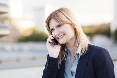 Smiling blond businesswoman on the phone - NAF000037