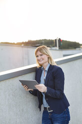 Smiling businesswoman with tablet looking at distance - NAF000044