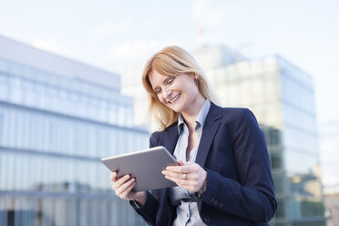 Content businesswoman looking at tablet - NAF000052