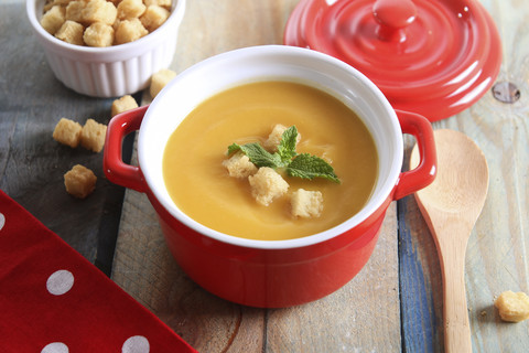 Topf Kürbiscremesuppe mit Brotwürfeln, lizenzfreies Stockfoto