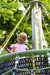 Kleines Mädchen in einer Nestschaukel auf dem Spielplatz - JFEF000802