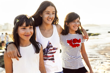 Drei glückliche Mädchen am Strand bei Sonnenuntergang - MGOF002264