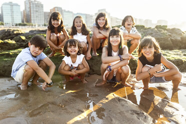 Eine Gruppe glücklicher Kinder am Strand bei Sonnenuntergang - MGOF002268