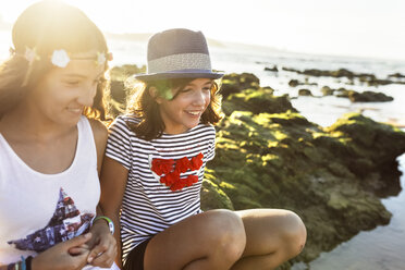 Zwei glückliche Mädchen am Strand bei Sonnenuntergang - MGOF002277
