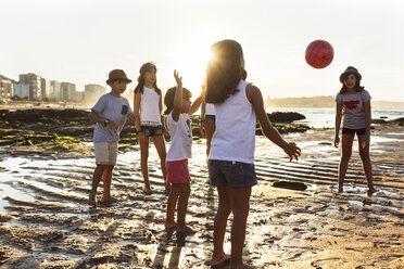 Kinder spielen mit einem Ball am Strand bei Sonnenuntergang - MGOF002281