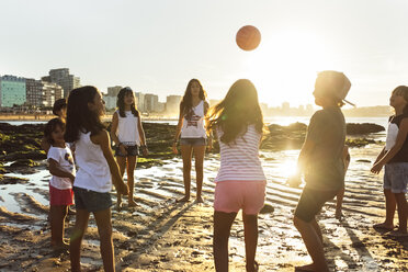 Kinder spielen mit einem Ball am Strand bei Sonnenuntergang - MGOF002282