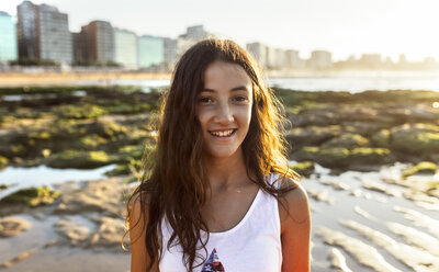 Portrait of a smiling girl on the beach at sunset - MGOF002286