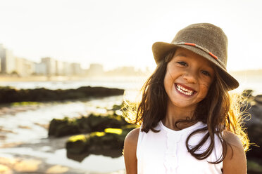Porträt eines lächelnden Mädchens am Strand bei Sonnenuntergang - MGOF002293