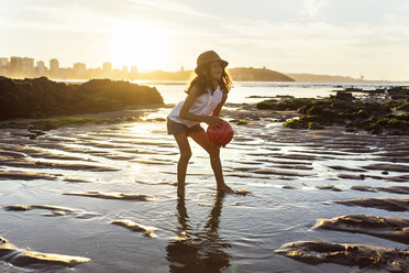 Girl playing with a ball on the beach at sunset - MGOF002304