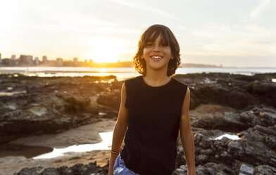 Smiling boy on the beach at sunset - MGOF002313