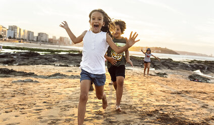 Kinder laufen bei Sonnenuntergang am Strand - MGOF002314