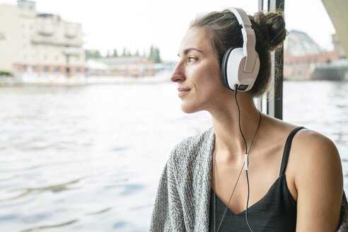 Entspannte Frau, die mit Kopfhörern Musik hört - TAMF000568