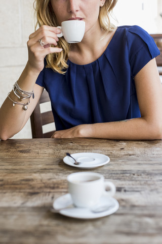 Frau trinkt Espresso in einem Straßencafé, Teilansicht, lizenzfreies Stockfoto