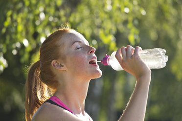 Sportler trinkt Wasser aus einer Flasche - YFF000559